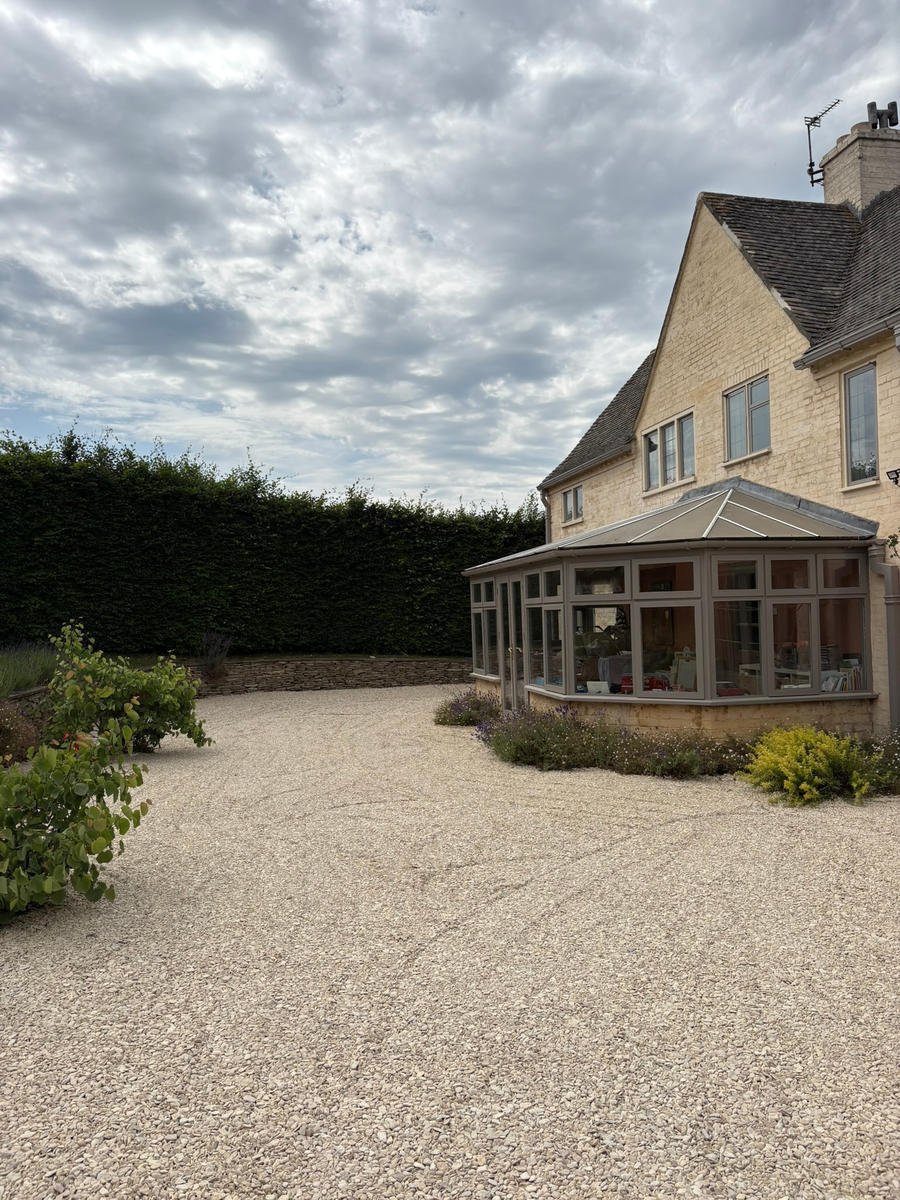 After: a finished self-binding gravel drive sweeping round to the conservatory