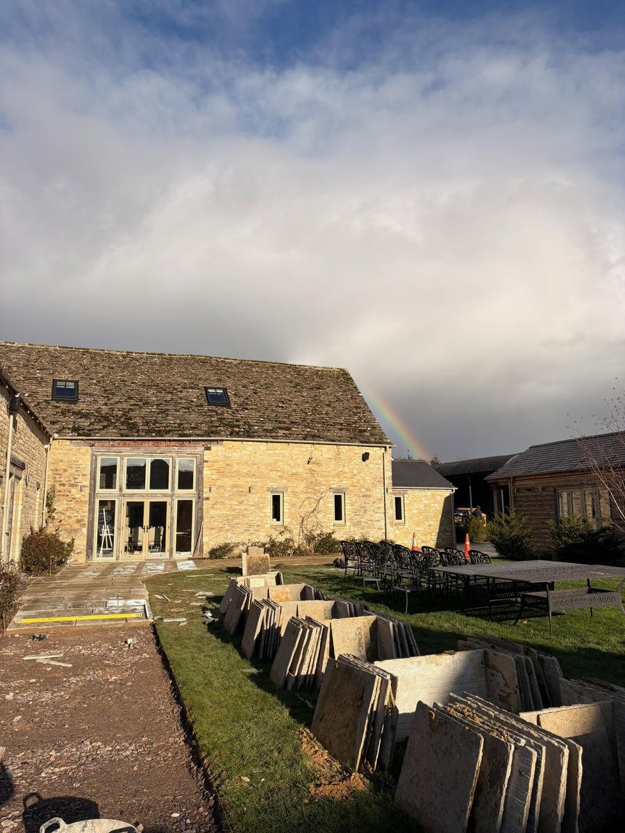 Before: old slabs lifted and stacked on the grass beside the courtyard