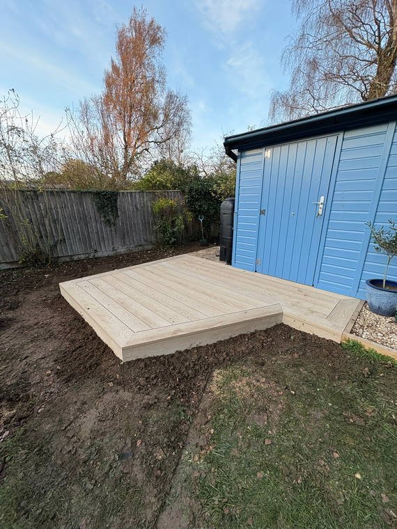 A composite deck laid in front of a blue-clad garden room
