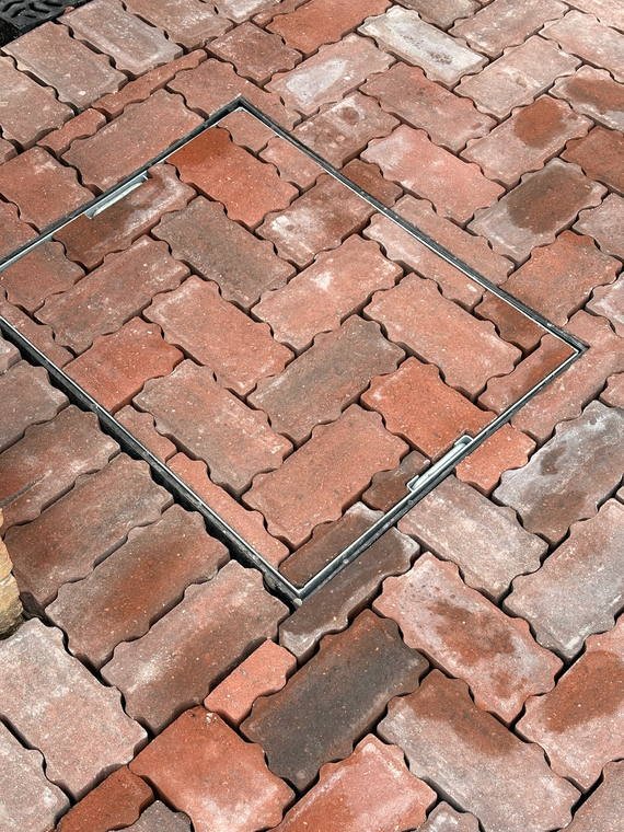 Block paving cut neatly around a recessed manhole cover