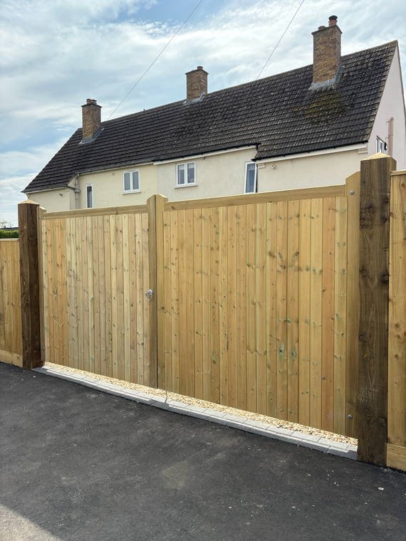 Tall close-board gates hung on new posts across a driveway