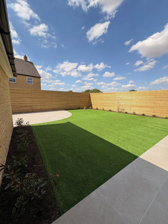 A new-build garden with artificial turf, a porcelain path and new close-board fencing