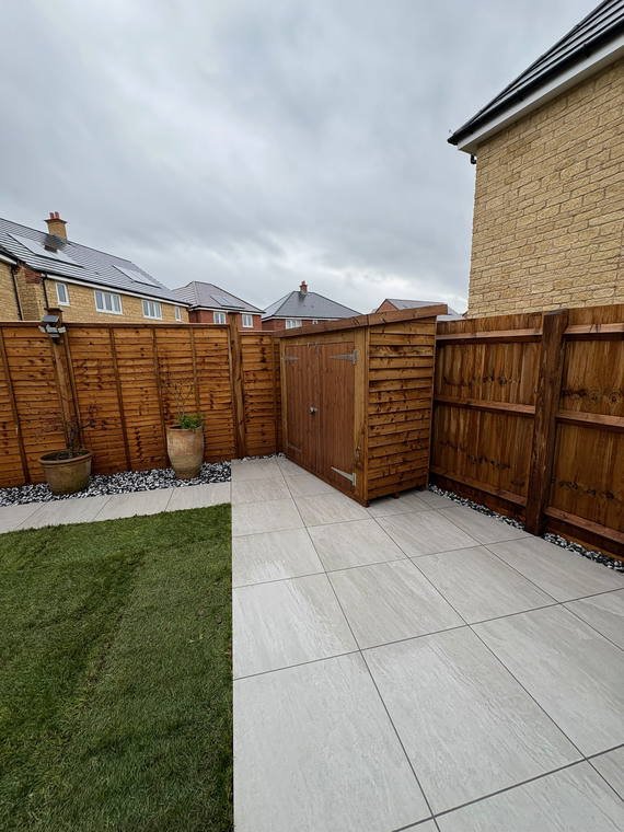 Porcelain paving, new turf and a shingle margin in a small enclosed garden