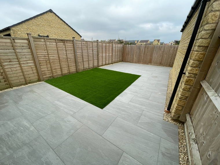 Porcelain paving wrapping a panel of artificial turf inside a walled garden