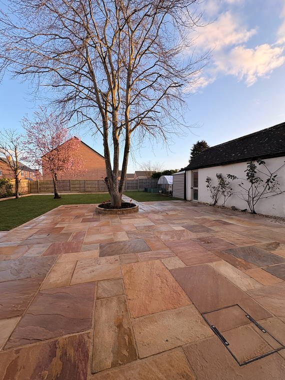 Indian sandstone terrace laid around a mature tree in a circular stone ring