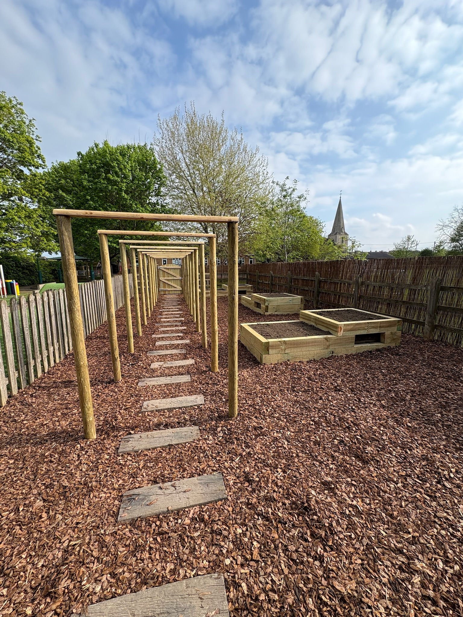 After: the finished archway walk with stepping stones, raised beds and the teepee beyond