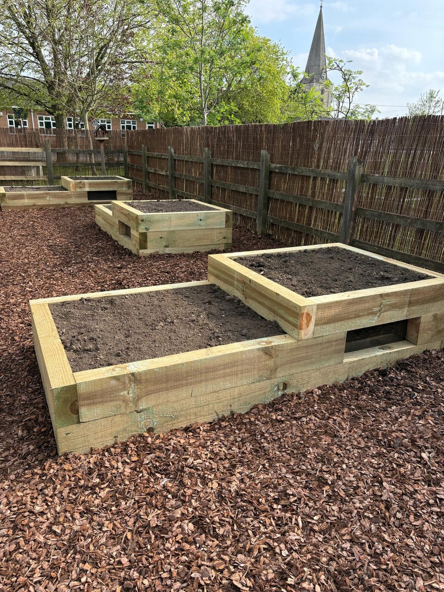 Timber raised beds with peep-hole windows built for a primary school growing garden