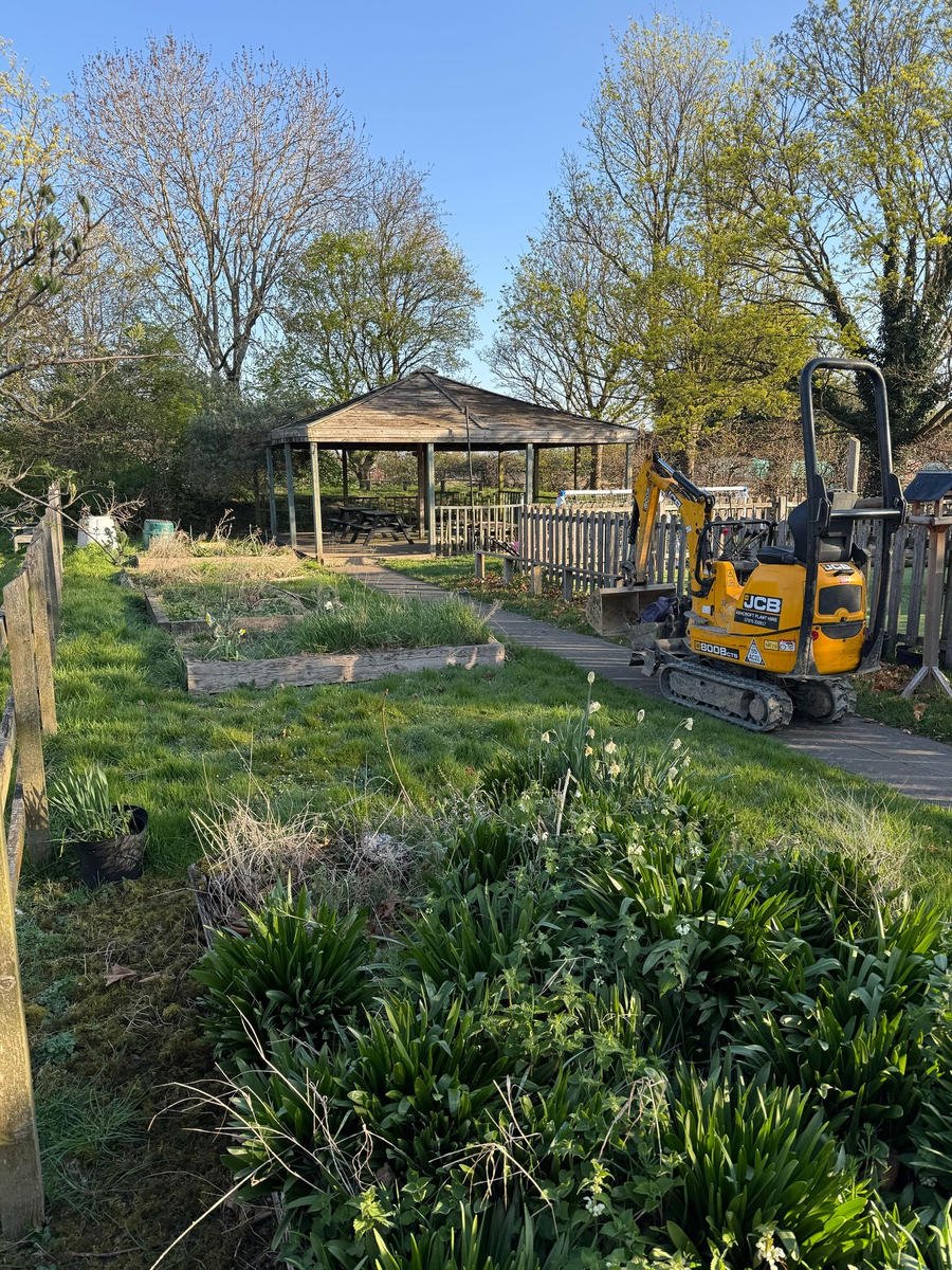 Before: the school ground overgrown with scrub, with a mini digger arriving