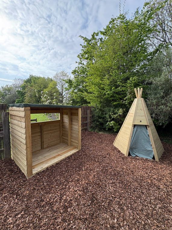 The finished bird hide and timber teepee on bark surfacing at the school