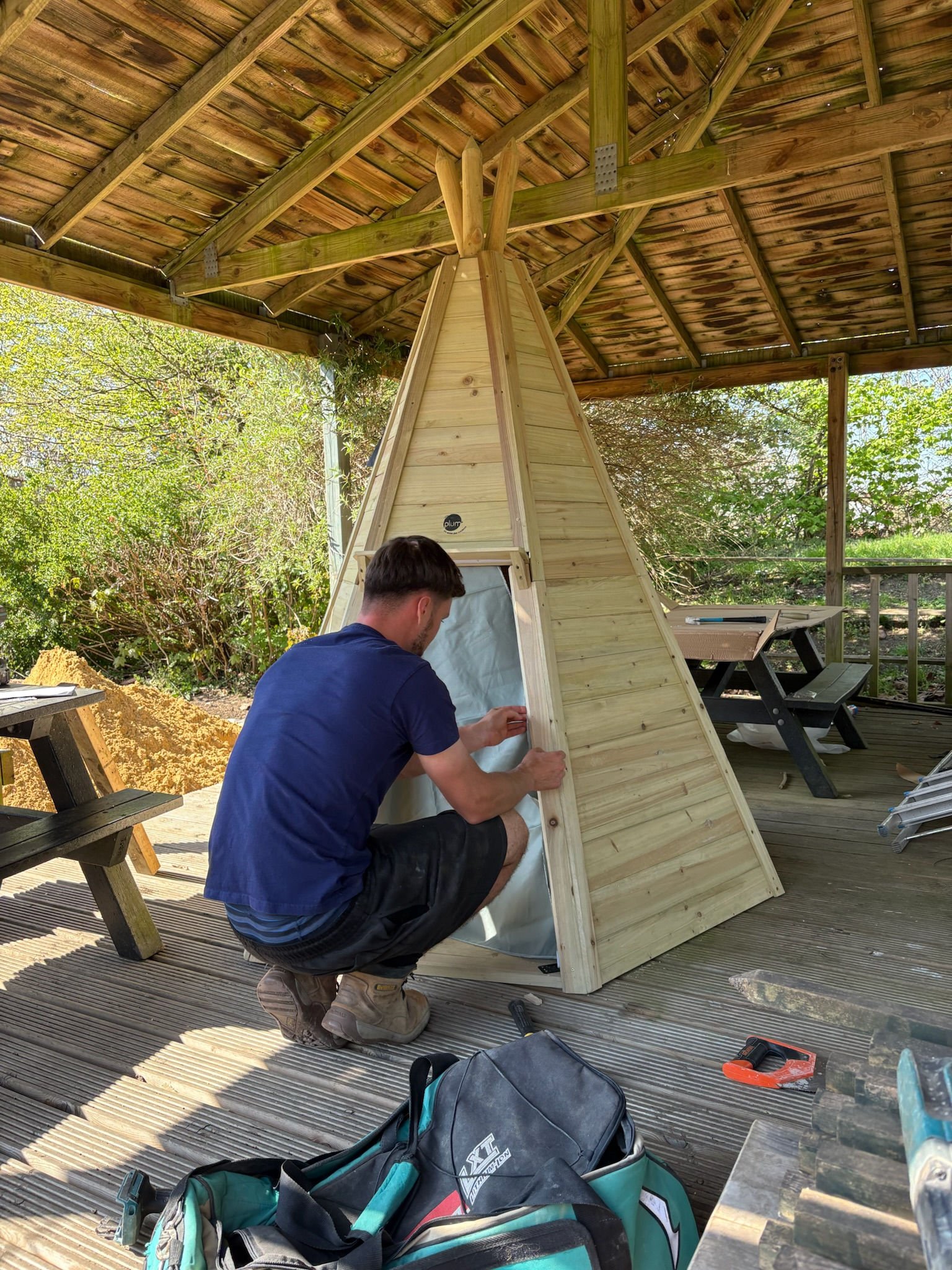 One of the JBM team fitting the timber teepee on the decking at a primary school