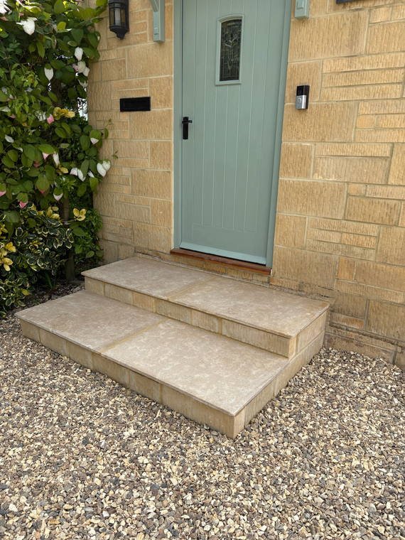 New stone steps rising to the front door of a Cotswold house