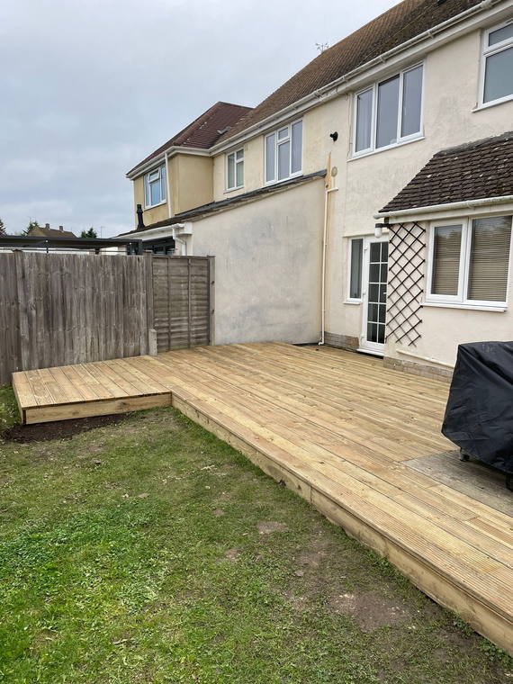 A composite deck laid off the back of a house onto a level lawn