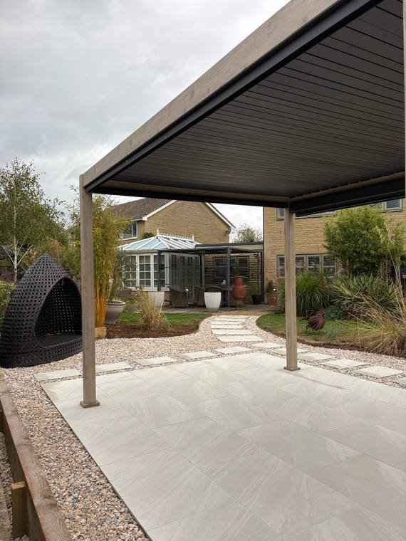A louvred aluminium pergola standing over a porcelain terrace